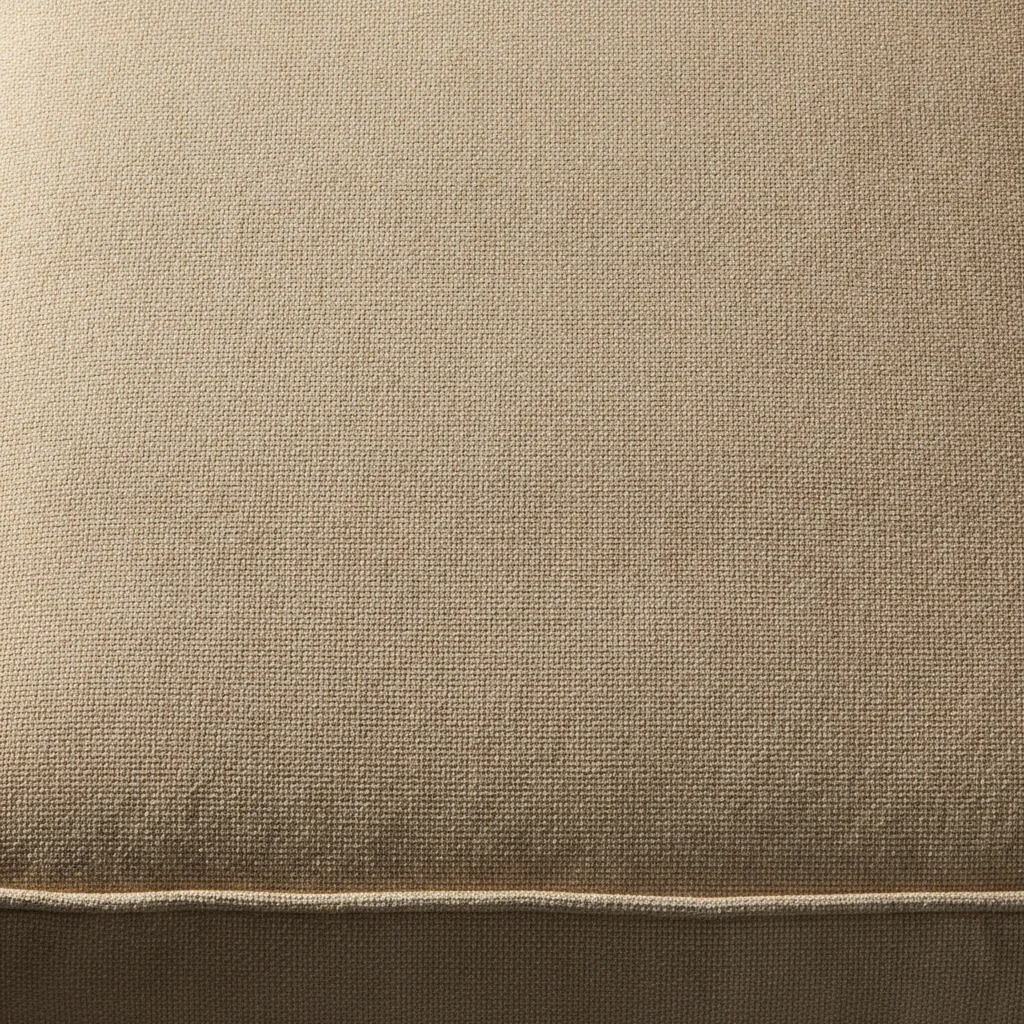 Beige cotton upholstered cushion with woven texture and fold shadows