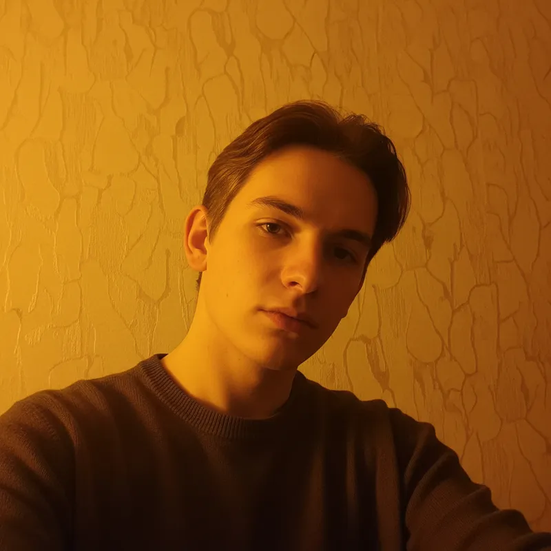 Dim webcam photo of student in home office
