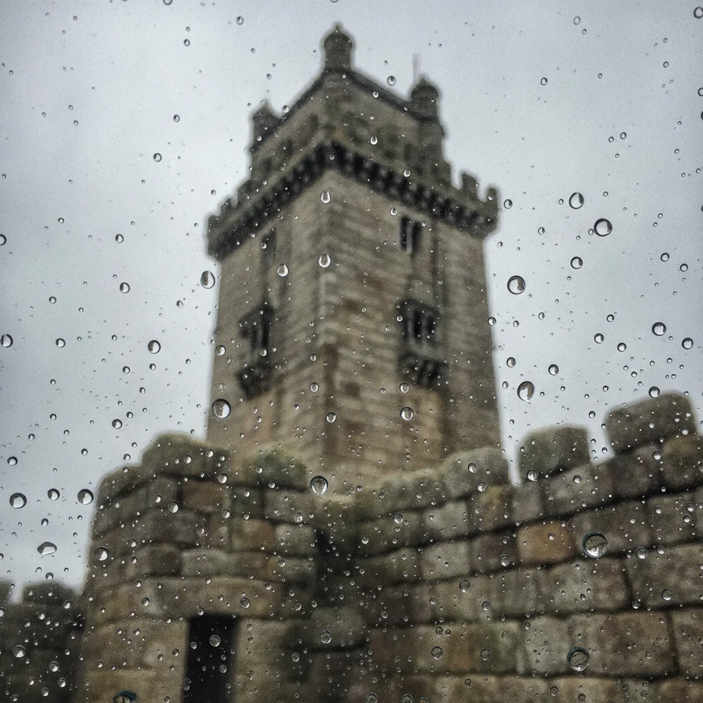 Stone landmark tower with water drops on the lens blurring the lower half of the frame